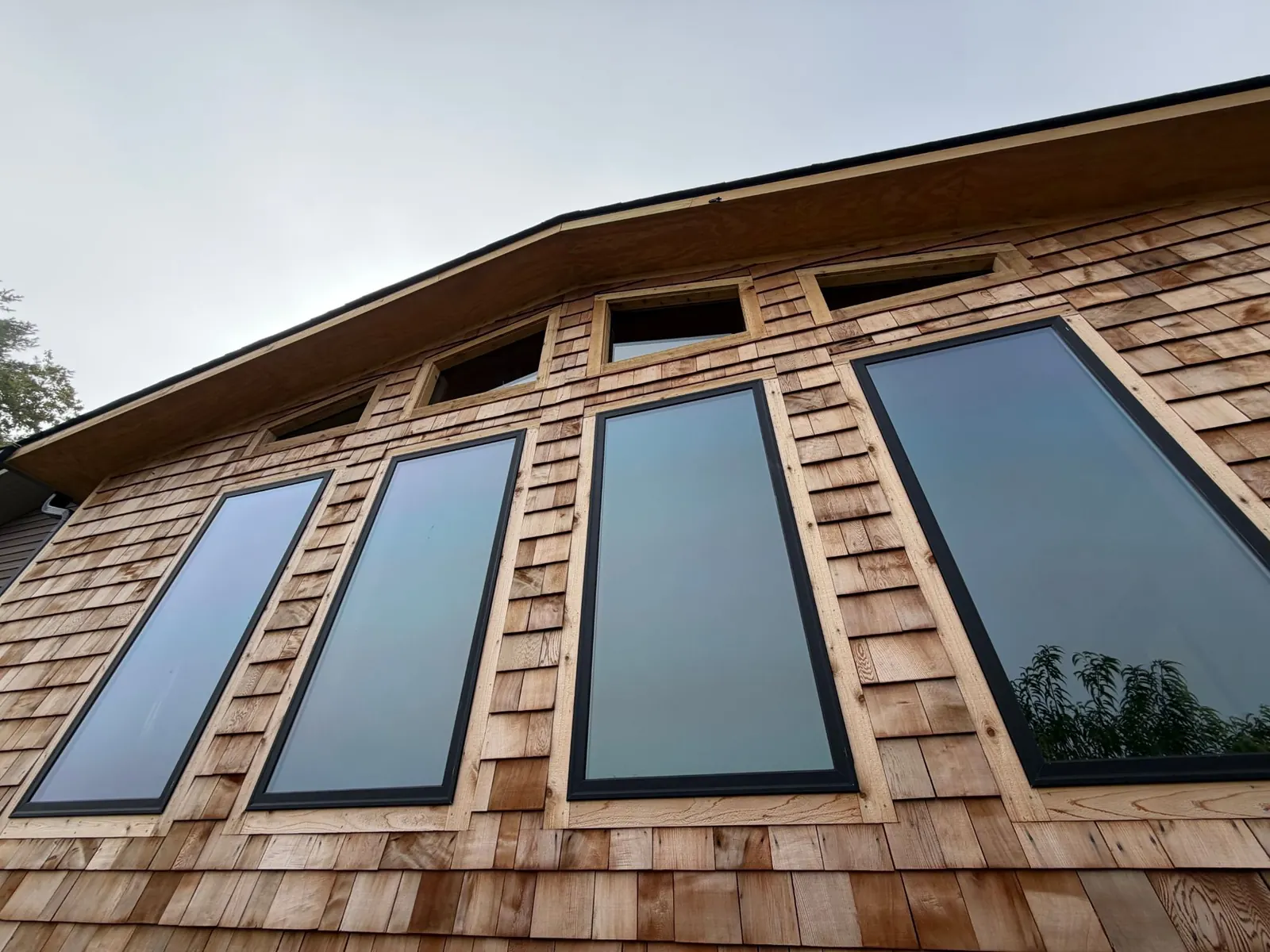 Cedar shake siding and tall windows with custom gable glass on a living room addition in Franklin, North Carolina