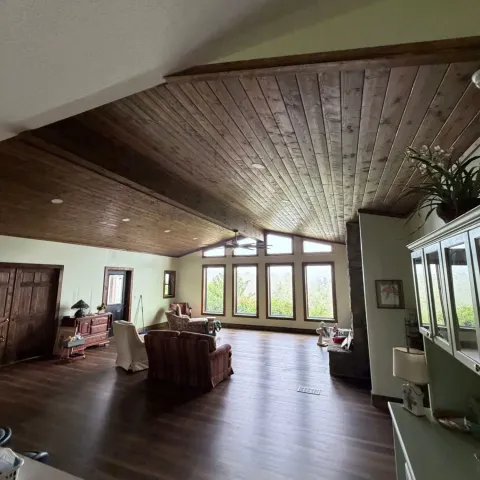 Living room addition by Highlander in Franklin, North Carolina, with a stained tongue-and-groove vaulted ceiling and a wall of mountain-view windows