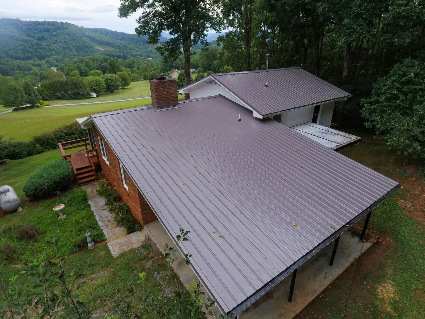 Brown metal panel roof completed on a brick home in Sylva, North Carolina