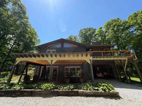 Open trellis converted to a covered patio with a metal roof and wood ceiling in Cashiers, North Carolina